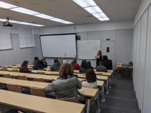 A classroom at Howard Payne University with students seated and a teacher standing by the whiteboard. | HPU