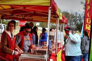 People at an outdoor concession stand at Howard Payne University with one person on the phone. | HPU