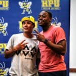 Two people posing for a photo in front of a backdrop with Howard Payne University logos. | HPU