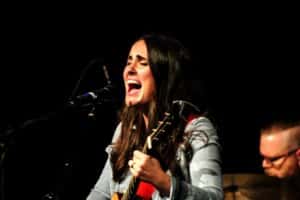 Female musician passionately singing and playing the ukulele on stage at Howard Payne University. | HPU