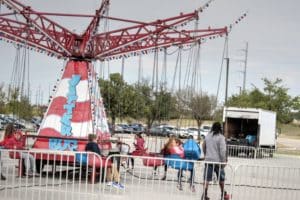 People waiting in line for an amusement park ride called "tilter" on a cloudy day, much like the excitement seen during Howard Payne University's annual carnival. | HPU