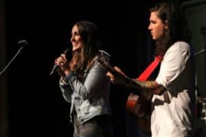Two musicians from Howard Payne University are on stage, one singing and the other playing the guitar. | HPU