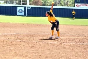Softball pitcher from Howard Payne University in mid-throw on the mound during a sunny game day. | HPU
