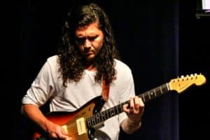 A guitarist focused on playing an electric guitar on stage at Howard Payne University. | HPU