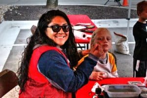 A woman face-painting a child at an outdoor event hosted by Howard Payne University. | HPU