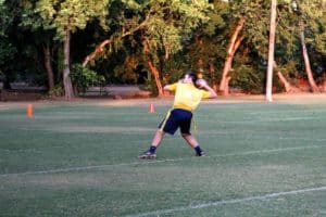 A person throwing a football in an open field at Howard Payne University at dusk. | HPU