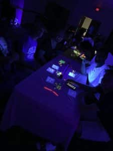 A group of Howard Payne University students playing video games in a dimly lit room with neon lighting. | HPU