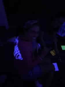 Woman smiling in a dimly lit room with blue lighting at Howard Payne University. | HPU