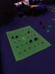 A Howard Payne University bingo card with some markers under dim blue lighting. | HPU