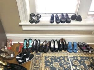 A collection of various shoes neatly lined up along a window sill and a carpeted floor inside a Howard Payne University dorm room. | HPU