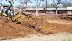 Excavator digging and moving earth at a Howard Payne University construction site. | HPU