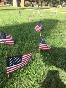 American flags placed on grass at Howard Payne University, possibly in remembrance or celebration. | HPU