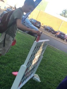 Man playing a large outdoor four-in-a-row game at Howard Payne University. | HPU