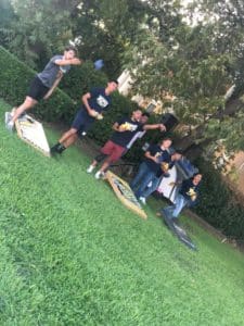 Group of people playing a bean bag toss game outdoors at Howard Payne University. | HPU