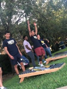 Group of people playing a game of cornhole outdoors at Howard Payne University. | HPU