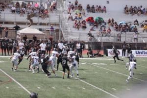 A Howard Payne University football game in progress with players on the field and spectators in the stands. | HPU