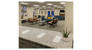 Modern office waiting area at Howard Payne University with couches, chairs, and decorative plants. | HPU