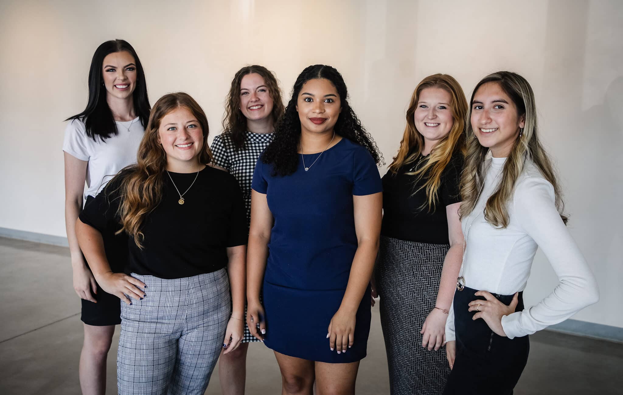 A group of six women smiling and posing for a photograph at Howard Payne University in a professional or casual business setting. | HPU