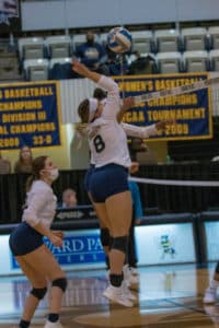 A Howard Payne University volleyball player jumping to hit the ball during a match indoors. | HPU