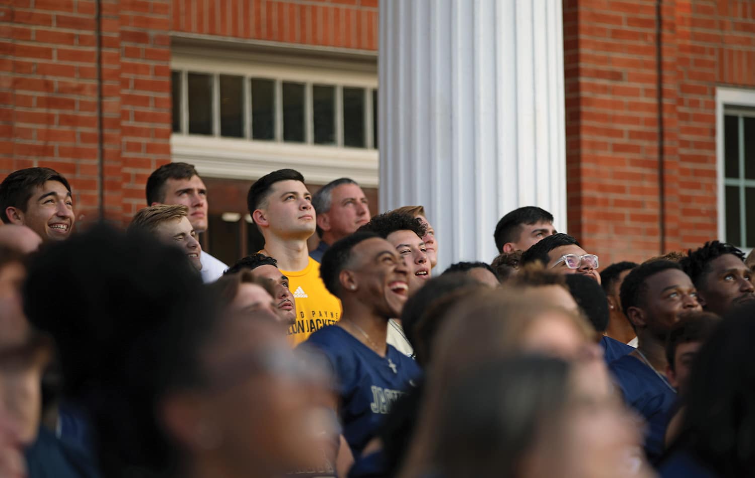 Group of Howard Payne University people looking attentively in the same direction, displaying various expressions of interest and engagement. | HPU