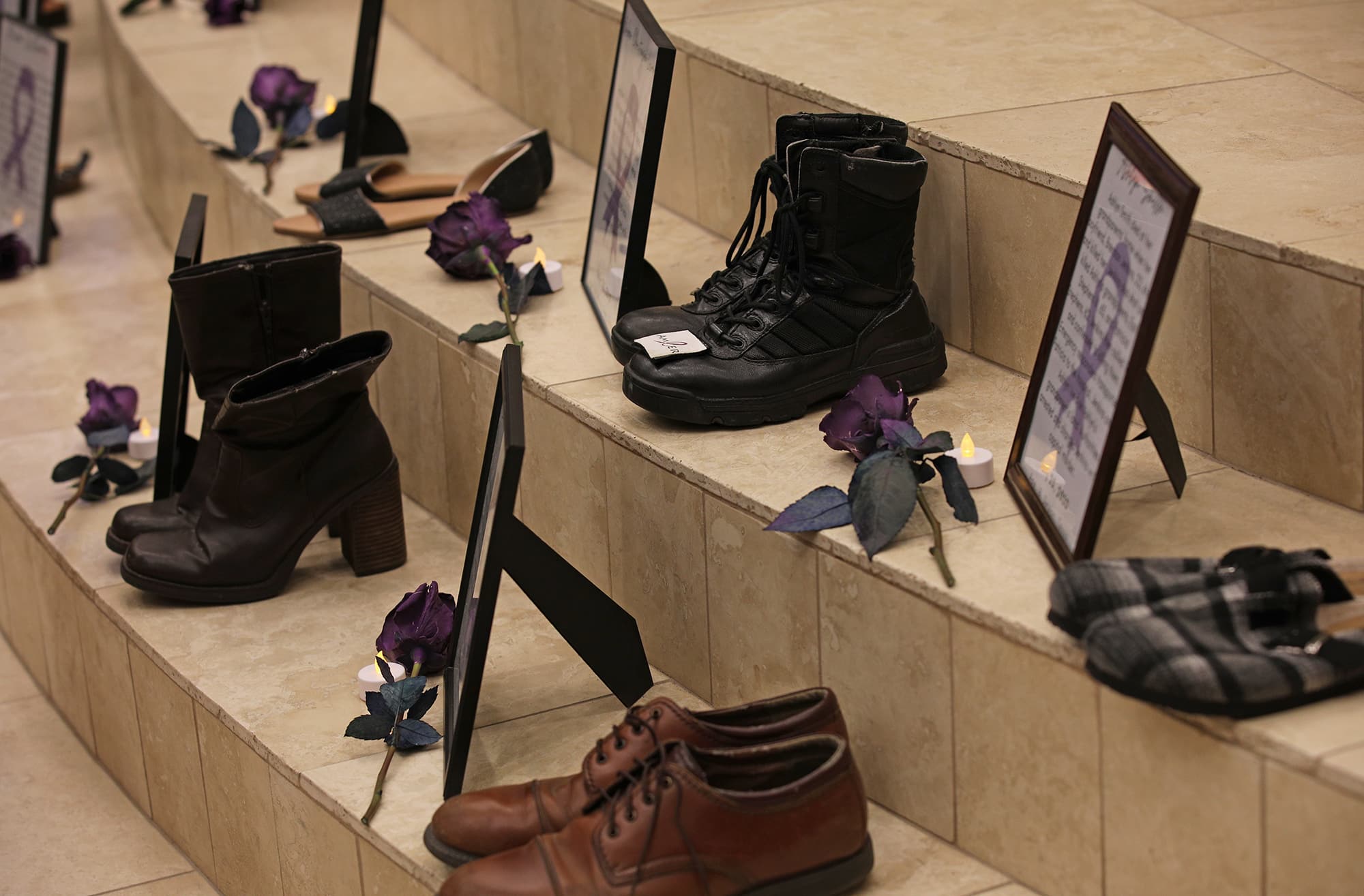 A display of various shoes and flowers scattered on stairs with informational cards at Howard Payne University. | HPU