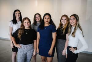 Group of six smiling women from Howard Payne University posing for a photo indoors. | HPU