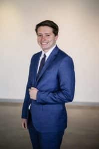 Man in a blue suit, associated with Howard Payne University, smiling at the camera. | HPU