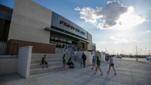 People approaching the entrance of Howard Payne University stadium under a partly cloudy sky. | HPU