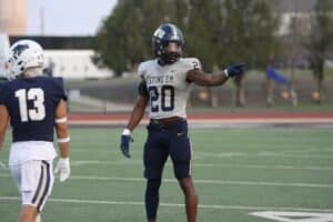 A Howard Payne University football player gesturing on the field during a game. | HPU