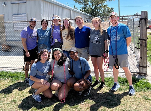 Group of smiling volunteers from Howard Payne University posing for a photo on a sunny day. | HPU