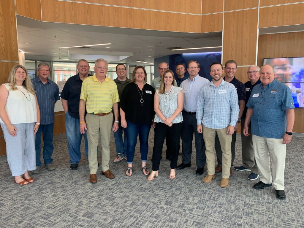 Group of professionals from Howard Payne University posing for a photo in an office setting. | HPU