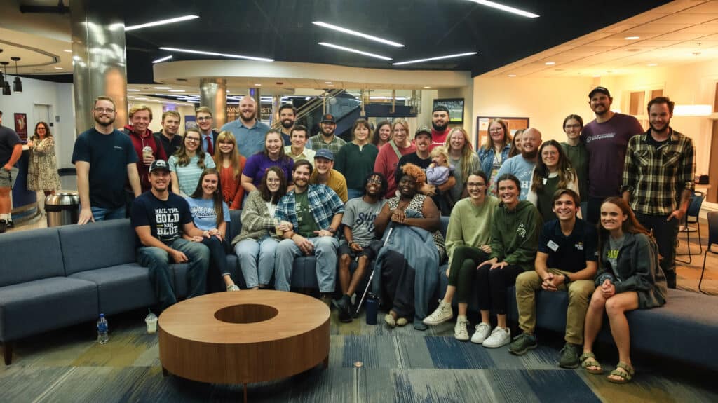 A large group of young HPU Alumni gather in the Mabee University Center.