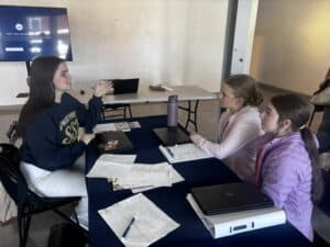 Rylie Burden giving one-on-one coaching to students from Hico High School.